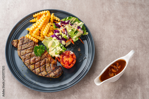 Grilled Sirloin Beef Steak with french fries and salads. Serve on Black Plate. Negative Space. photo