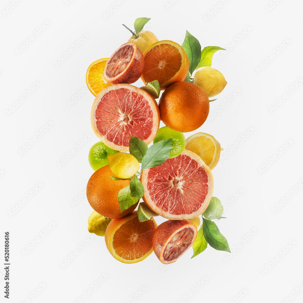 Flying various citrus fruits setting with green leaves at white background. Grapefruit, lemon, orange and lime flying in the air. Levitation. Healthy food concept. Flying various citrus fruits setting with green leaves at white background. Grapefruit, lemon, orange and lime flying in the air. Levitation. Healthy food concept.