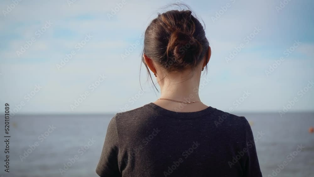 Unrecognizable ukrainian woman refugee standing near sea shore and thinking about suicide because war and armored invasion. Concept of peaceful and carefree life without armed conflicts Unrecognizable ukrainian woman refugee standing near sea shore and thinking about suicide because war and armored invasion. Concept of peaceful and carefree life without armed conflicts