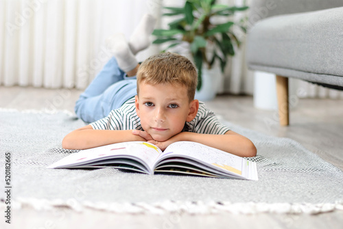 boy lying on the floor with a book