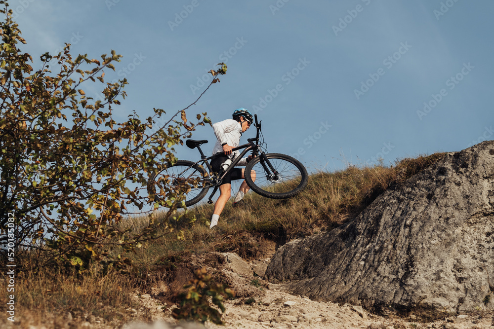Professional Male Cyclist Carrying His Bike on Top of the Hill, Adult Sportsman on Trail Professional Male Cyclist Carrying His Bike on Top of the Hill, Adult Sportsman on Trail