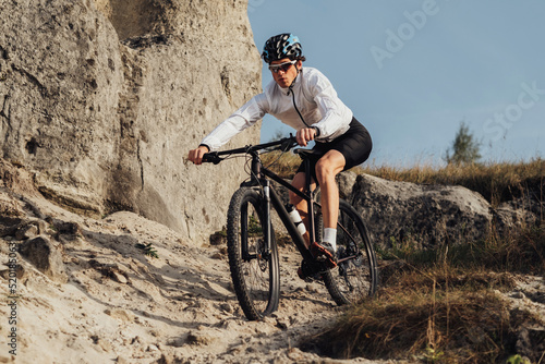Equipped Professional Cyclist Descends a Slope on His Mountain Bike, Sportsman Going Down from Hill on Bicycle