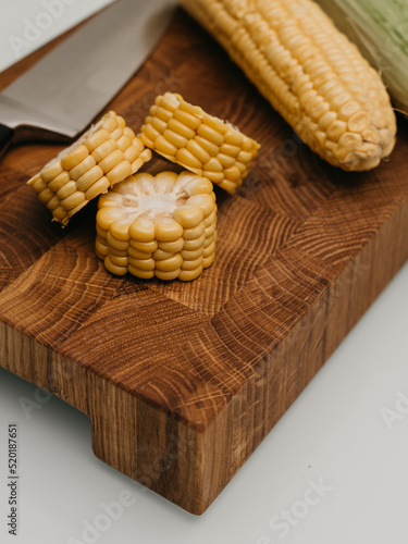 corn on a wooden cutting board table with knife