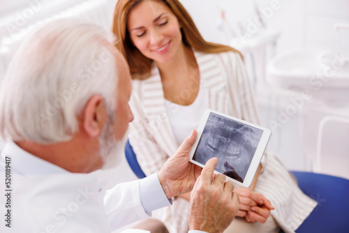 Woman at dental clinic consulting with dentist