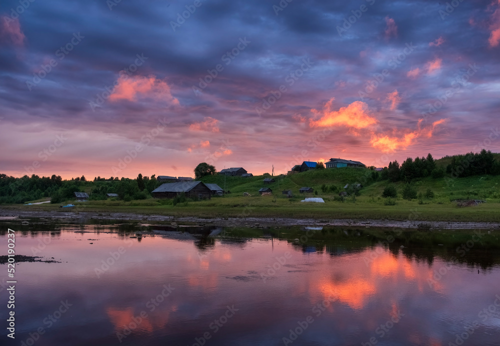 The ancient Pomeranian village of Punerma in the Arkhangelsk region, in the summer at sunset on banks of the river
