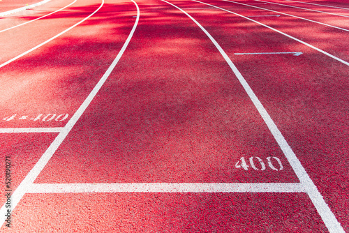 Bright red running track with white line and number 400.Close-up. photo