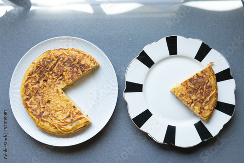 Bild auf Leinwand Potato omelette in two plates, one white and grey, and one black and white