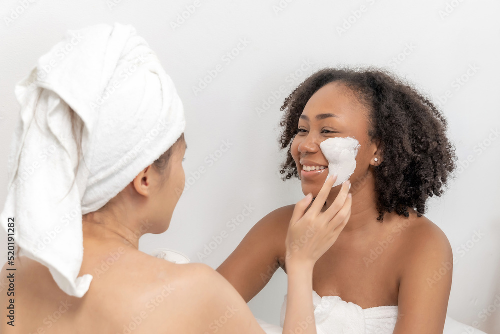 two beautiful young girl friend in towel applying white nourishing mask on face in bed room at home, facial treatment, skin care, cosmetic, beauty treatments spa, healthy body, facial mask concept two beautiful young girl friend in towel applying white nourishing mask on face in bed room at home, facial treatment, skin care, cosmetic, beauty treatments spa, healthy body, facial mask concept