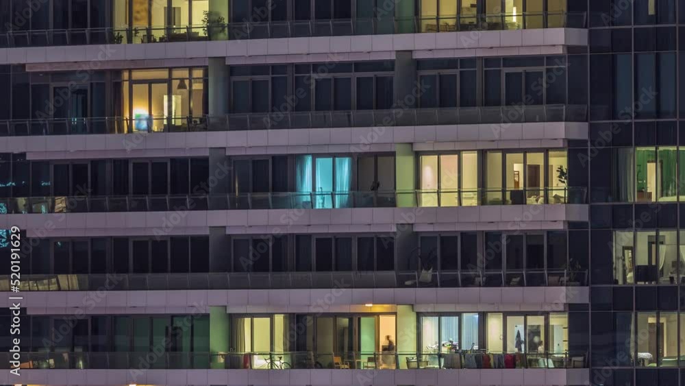 Windows lights in modern office and residential buildings timelapse at night. Multi-level skyscrapers with illuminated apartments inside Windows lights in modern office and residential buildings timelapse at night. Multi-level skyscrapers with illuminated apartments inside