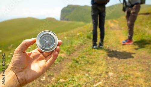 Traveler holding compass in nature background.