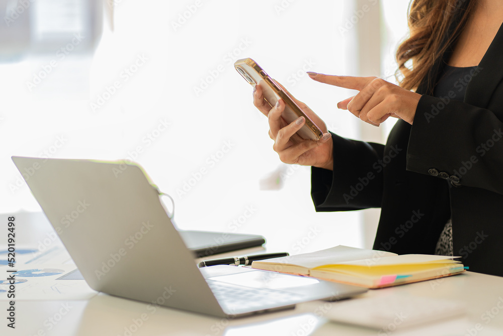 A businessman holding a smartphone working on project statistics on the device is ready. Graph presentation, notebook, entrepreneur, financial market data analysis. that represents a change A businessman holding a smartphone working on project statistics on the device is ready. Graph presentation, notebook, entrepreneur, financial market data analysis. that represents a change