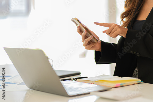 A businessman holding a smartphone working on project statistics on the device is ready. Graph presentation, notebook, entrepreneur, financial market data analysis. that represents a change