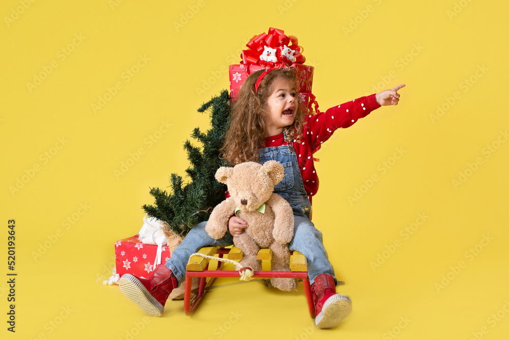 Girl with new year gifts on yellow background for copy Girl with new year gifts on yellow background for copy