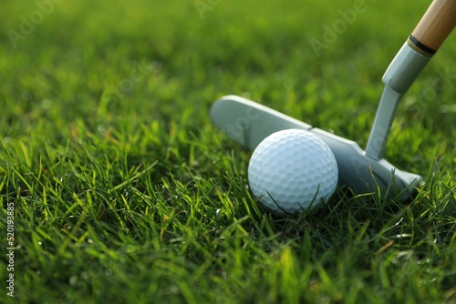 Hitting golf ball with club on green course, closeup. Space for text