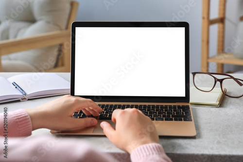 Woman working on laptop at white table, closeup. Mockup for design