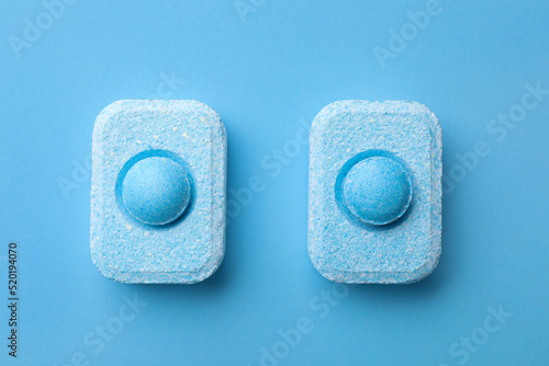 Water softener tablets on light blue background, flat lay