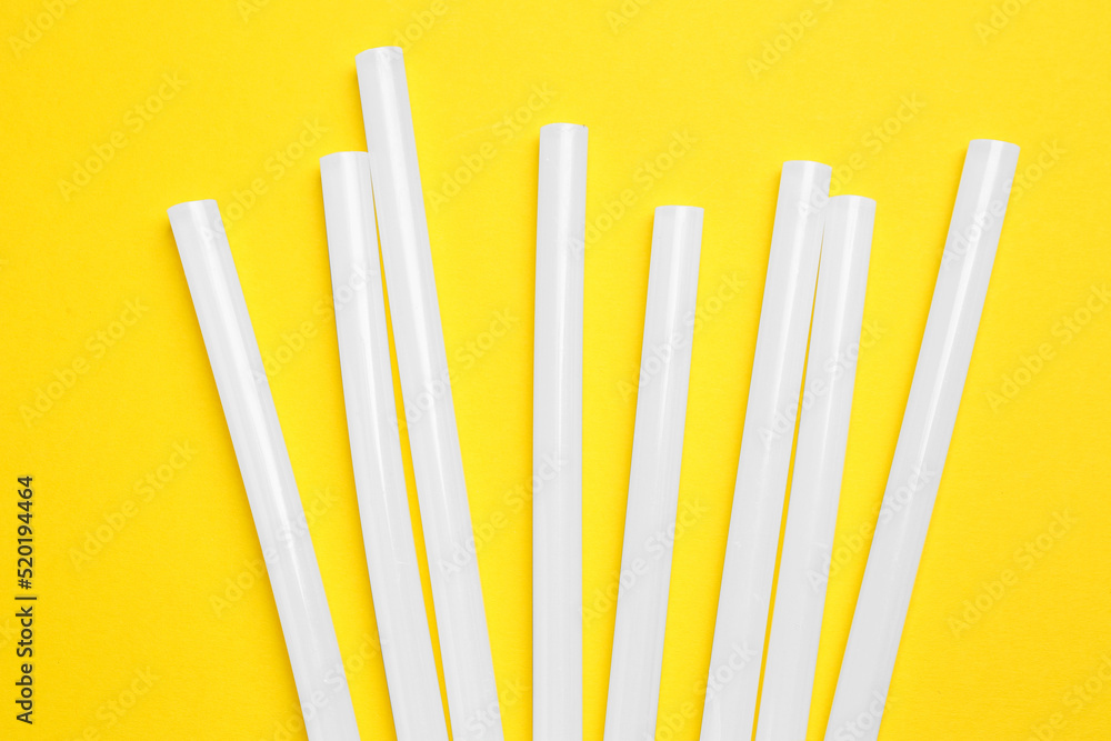 Many glue gun on yellow background, flat lay Many glue gun on yellow background, flat lay