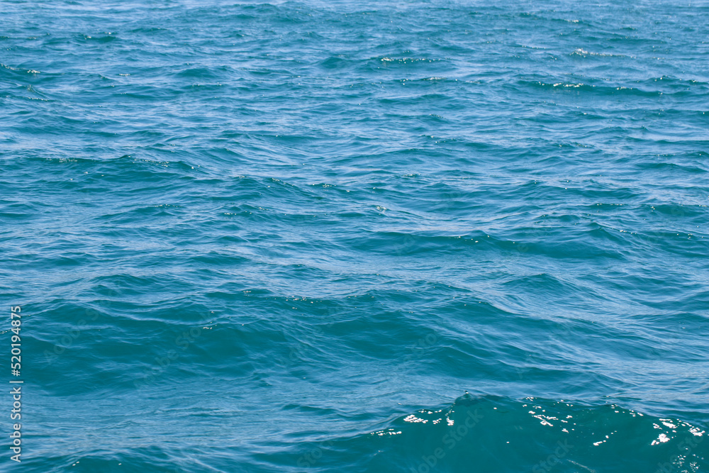 Sea surface. Turquoise sea water. Close up blue water surface at deep ocean Sea surface. Turquoise sea water. Close up blue water surface at deep ocean