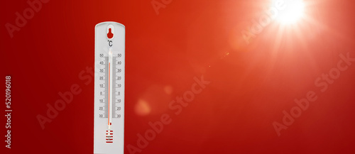 Thermometer mit heissen Celsiusgraden vor rotem Hintergrund