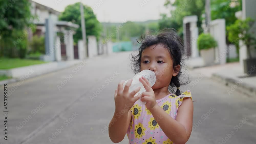 Thirsty Little girl drinking fresh water from plastic bottle at street. Thirsty Little girl drinking fresh water from plastic bottle at street.