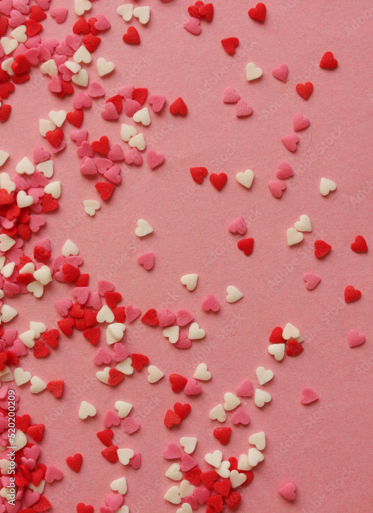 Multicolored background with candy hearts. Pink, white, red hearts. Love. Simovl loves. Valentine is Day. Lots of little hearts. Copy space for text. Vertical photo