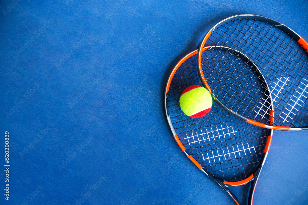 Φωτογραφία Children's Tennis ball and Tennis Rackets on blue background