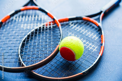 Children's Tennis ball and Tennis Rackets on blue background.