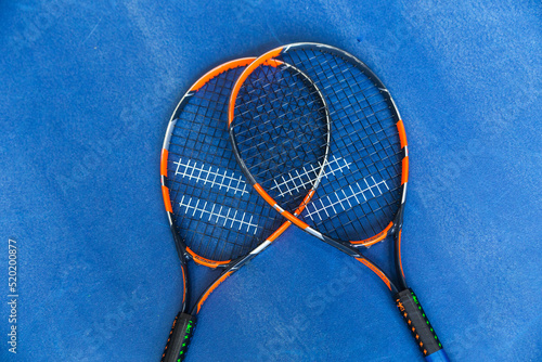 Two tennis rackets on a blue background. Top view