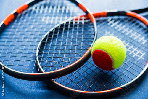 Children's Tennis ball and Tennis Rackets on blue background.