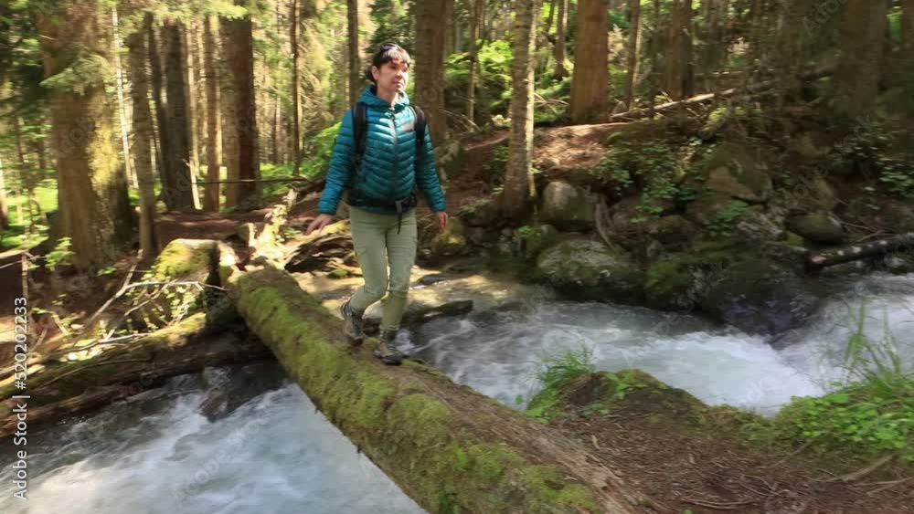 Hiking woman walk with a hiking backpack in spring green forest