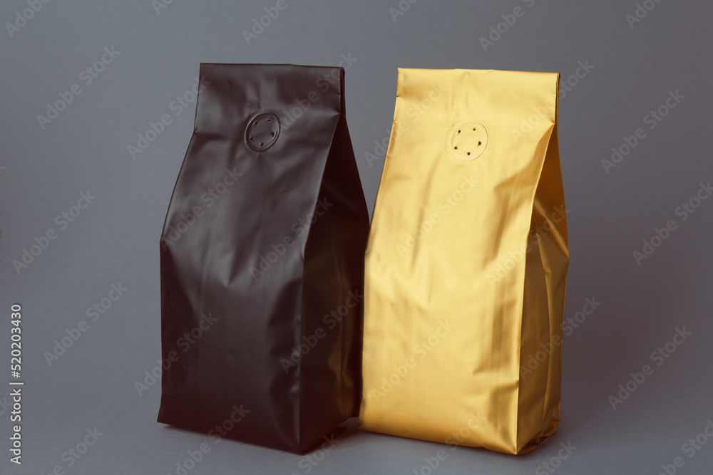 Different blank foil packages on grey background