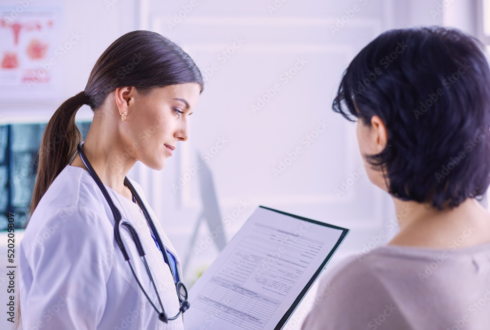 Beautiful female doctor explaining medical treatment to a patient Beautiful female doctor explaining medical treatment to a patient