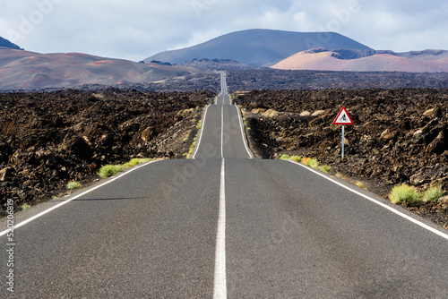 Asphalt road LZ-67 leading to Timanfaya National Park, in Lanzarote, Canary Islands, Spain