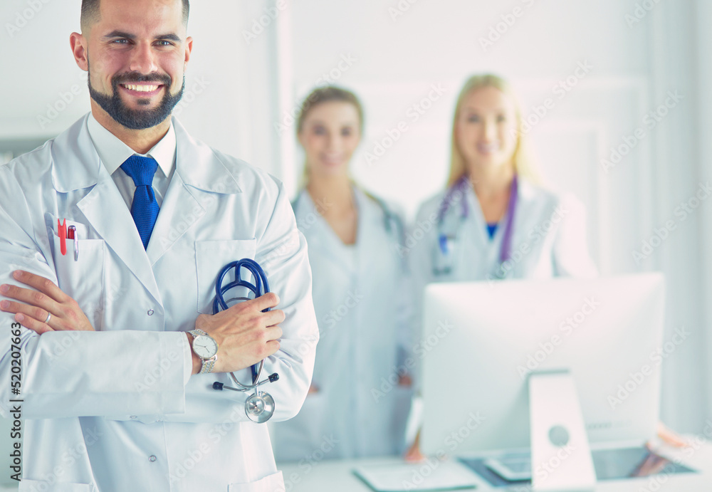 Young male doctor in front of medical group Young male doctor in front of medical group