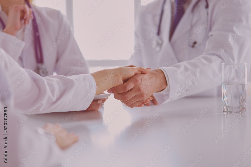 Doctor shaking hands with a male patient in the office Doctor shaking hands with a male patient in the office