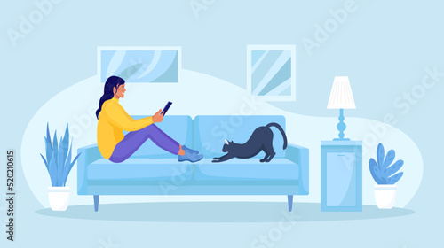 Young girl using tablet pc or phone, lying on sofa at home and reading news. Woman running remotely on freelance. Surfing on the internet, shopping online or social media communication