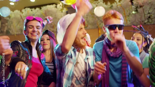 Footage of a crowd or group of young, stylish multi-ethnic people during colorful party in different clothes . Dancers having fun dancing at a party . Shot on RED HELIUM Cinema Camera in slow motion .