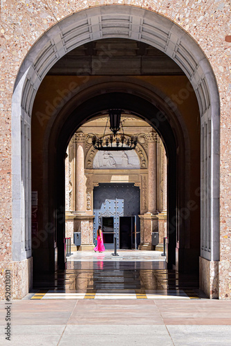 Chica con un vestido rosa entrando en un templo