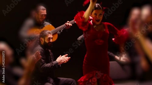 Beautiful stylish female artist dancing spanish style dance . Group of men playing on guitar and applauds to the dancer woman . Concept footage of spanish traditional culture . Waving cloth of skirt  photo