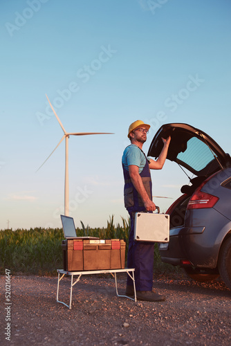 Engineer mechanic in a windmill farm park checking and servicing wind turbines.