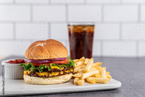 Double hamburger with cheese with fries and a drink  photo