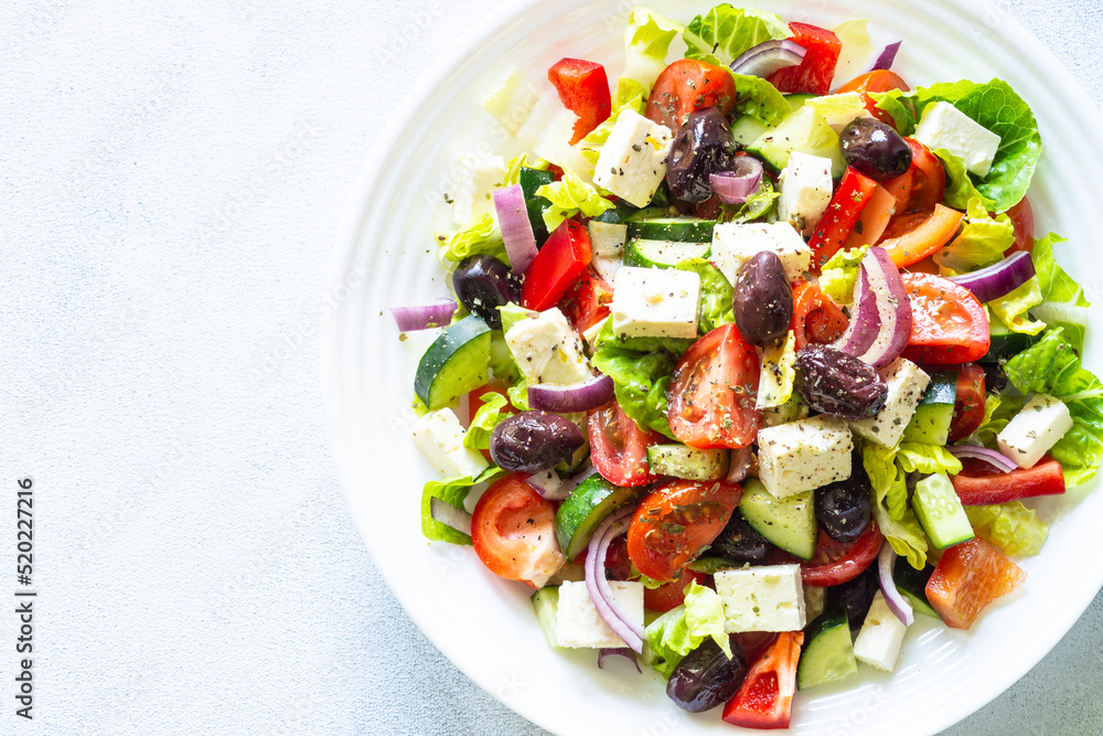 Greek salad. Vegetable salad with tomato, cucumber, feta cheese, greek olives and olive oil. Top view, close up. Greek salad. Vegetable salad with tomato, cucumber, feta cheese, greek olives and olive oil. Top view, close up.
