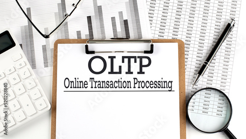 Paper with OLTP - Online Transaction Processing a table on charts, business concept photo