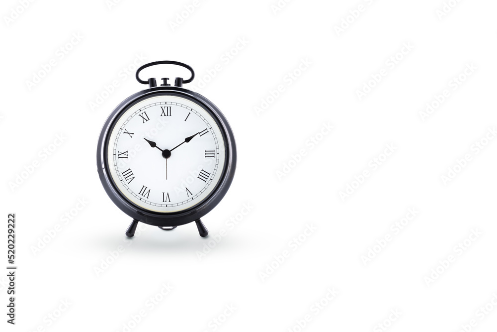 The time, classic black alarm clock with white dial and Roman numerals with a large white negative space. The time, classic black alarm clock with white dial and Roman numerals with a large white negative space.