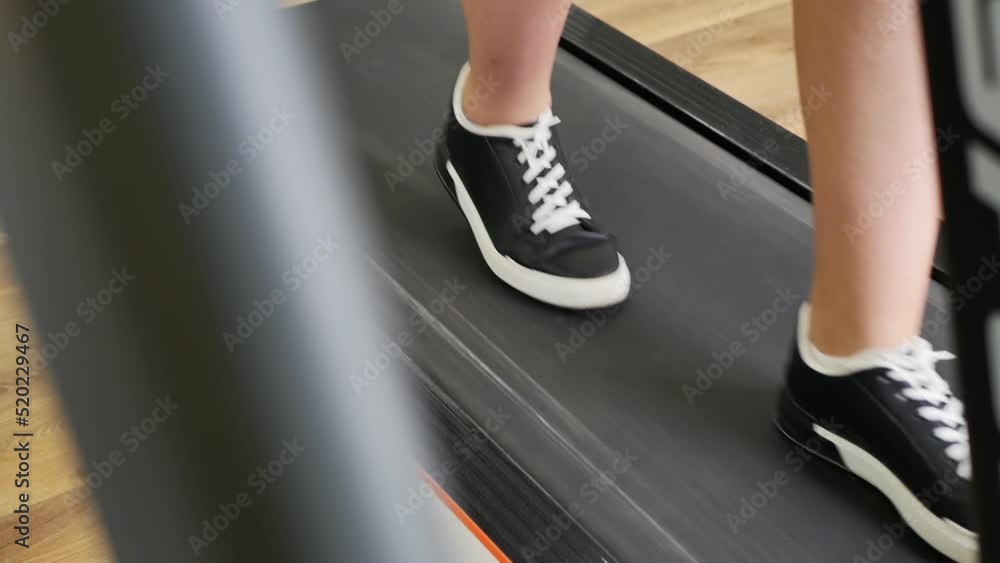 a woman in black and white sneakers walks with a calm step on a