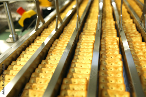 A lot of cookies on the production line. The flow of sweets before packaging. Packing crackers on the machine. Innovative production.