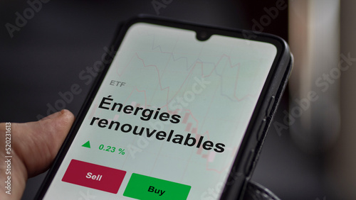 Un investisseur analyse un fonds etf énergies renouvelables sur un graphique. Un téléphone affiche le cours de l'ETF Énergies renouvelables