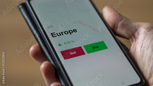 Un investisseur analyse un fonds etf europe sur un graphique. Un téléphone affiche le cours de l'ETF. Texte en français francais Europe