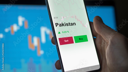 Un investisseur analyse un fonds etf pakistan sur un graphique. Un téléphone affiche le cours de l'ETF. Texte en français francais Pakistan