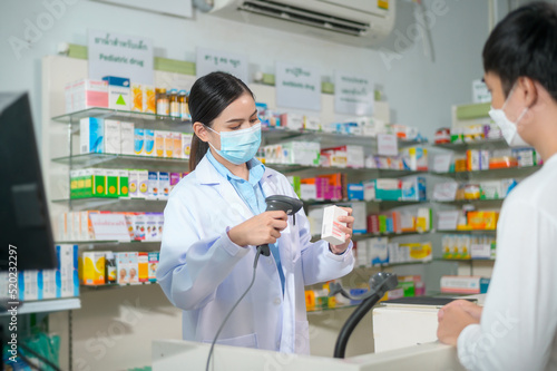 Portrait of female pharmacist wearing face mask in a modern pharmacy drugstore.